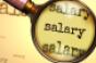 Salary and a magnifying glass on English word Salary to symbolize studying, examining or searching for an explanation and answers related to a concept